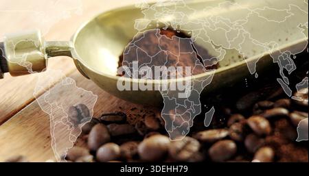 Displaying brass coffee scoop holding ground coffee on wooden tabletop, showing world map overlay Stock Photo
