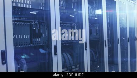 Showing glass door server racks in server room aisle holding switches, patch panels, cables, LEDs Stock Photo