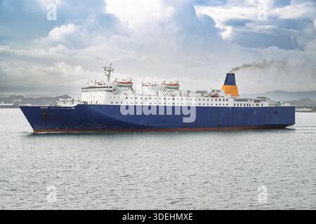 Caribbean Sea ferry boat in motion, cutting through azure waters toward a lush tropical island destination Stock Photo