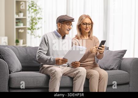 Mature couple reading documents on a sofa Stock Photo