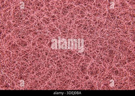 Detailed view of a pink scouring pad revealing its rough, fibrous, and textured surface, perfect for cleaning backgrounds Stock Photo
