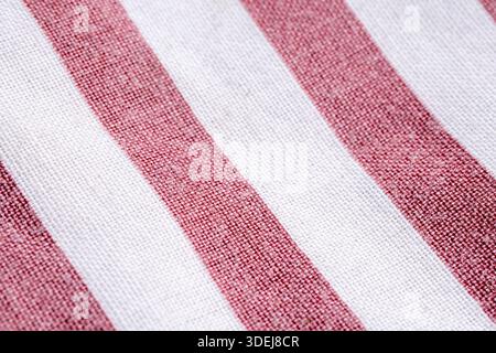 Extreme close-up of a woven fabric with vertical red and white stripes. High-quality textile texture for nautical and fashion design. Stock Photo