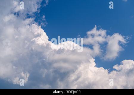 A peaceful and serene scene showcasing fluffy white clouds beautifully set against a vibrant blue sky above Stock Photo