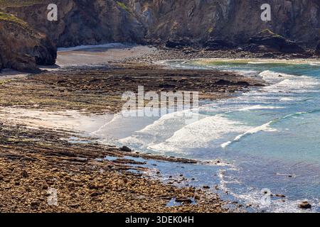 Breaking waves on a stoney beach at the coast Stock Photo