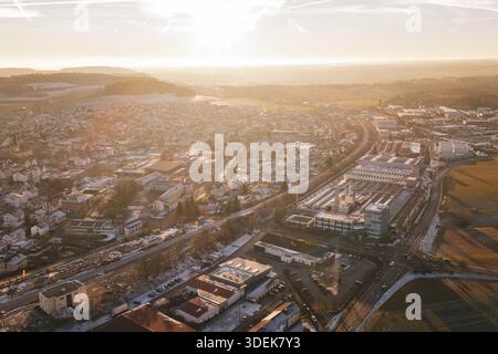 Sunset over a town with fields and industrial complexes in the foreground, Althengstett, Calw district, Germany Stock Photo