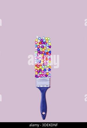 Gems. Gemstones heart shape composition. Creative layout made of multi colored glass gems and paint brush on pink pastel background. Minimal Flat lay. Stock Photo