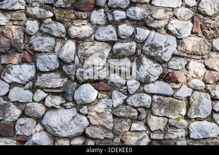 Closeup of old rough gray stone wall surface Stock Photo