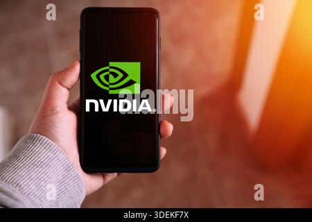 Hand holding smartphone with Nvidia logo displaying on screen. Nvidia Corporation is an American multinational technology company. Stock Photo