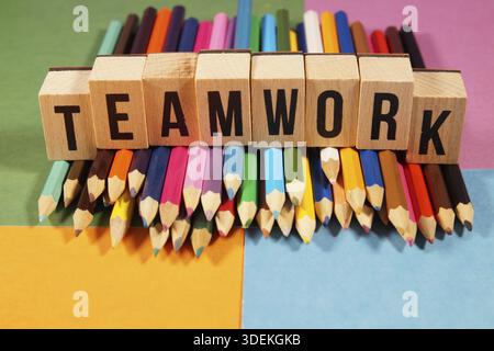 Word Teamwork on wooden cubes - lots of multicolored pencils on multicolored tones background. symbol of leadership, teamwork, success and unique. Tea Stock Photo