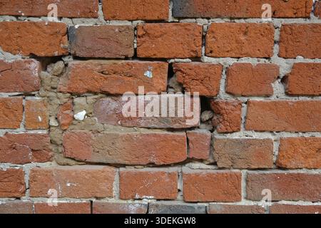 Embossed textured surface of the old orange brick and cement wall Stock Photo