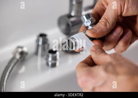 Plumber apply teflon seal tape on the plumbing fitting thread Stock Photo