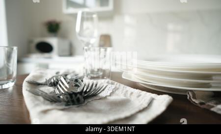 Clean Dishes And Forks Lying On The Table In The Kitchen Stock Photo
