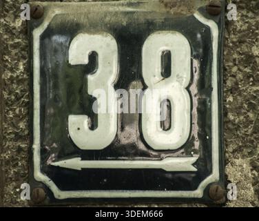 Weathered grunge square metal enameled plate of number of street address with number 38 closeup Stock Photo