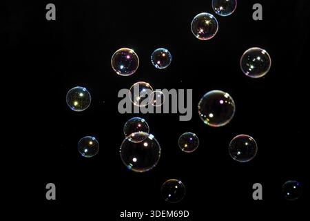 Beautiful multicolored soap bubbles on black background for texture and background Stock Photo