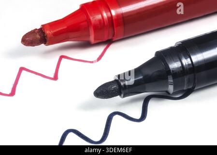 Black and red markers on a white sheet of paper with lines Stock Photo