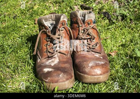 Old used weathered moldy grunge man's leather shoes on green grass field Stock Photo