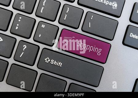 Ð¡omputer keyboard with shopping cart icon and word Shopping on magenta enter button. Online shop concept Stock Photo