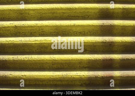 Old retro grunge weathered yellow corrugated roller shutter shop detail closeup as background Stock Photo