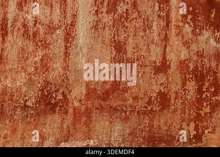 Old red painted fade colors plastered house wall as background Stock Photo