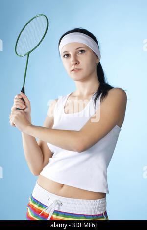 Beauty woman with badminton racket isolated on blue Stock Photo