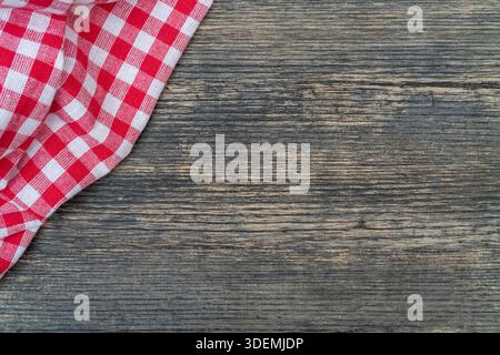 Red checkered towel on the kitchen table. Wooden table background. Stock Photo