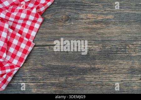 Red checkered towel on the kitchen table. Wooden table background. Stock Photo