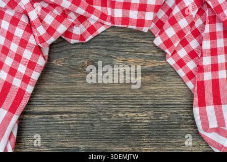 Red checkered towel on the kitchen table. Wooden table background. Stock Photo