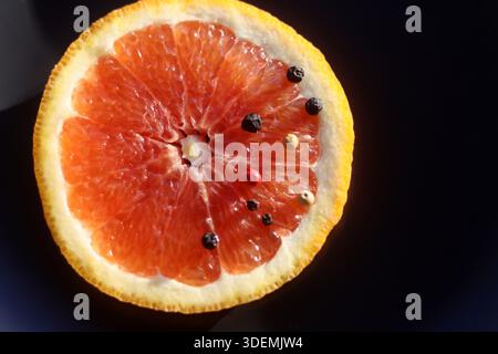 Grapefruit with black pepper on a black background Stock Photo