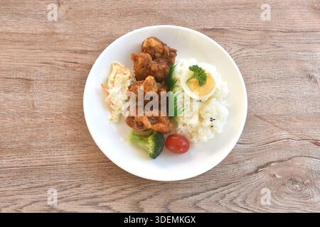 crispy fried garlic chicken with boiled egg on black sesame rice and salad bento set in plate Stock Photo