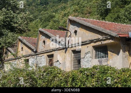 Old obsolete industrial building facade with broken windows Stock Photo