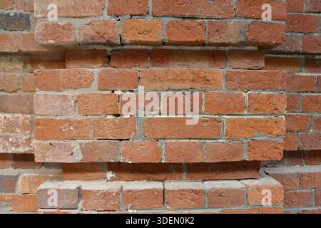 Embossed textured surface of the old orange brick and cement wall Stock Photo