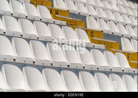 Rows of white and yellow stadium seats arranged in a repeating pattern Stock Photo