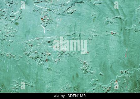 Grunge weathered cracked painted plastered wall closeup as green background Stock Photo