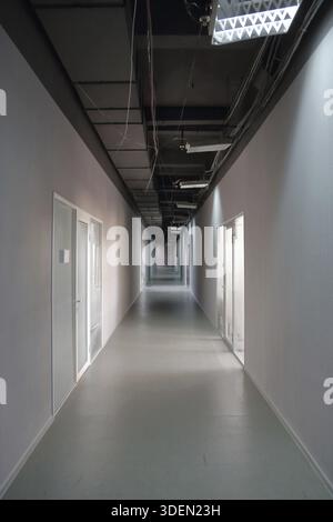Long narrow corridor with doors in the office or workplace Stock Photo