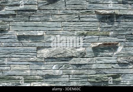 Fence wall made from tiles of gray blue sandstone as background Stock Photo