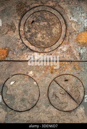 Rusty weathered antique cast iron wood stove burner cover plates Stock Photo