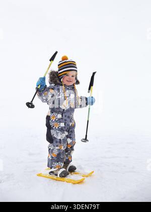Small child, toddler 2, 5 years, first time up on skis Stock Photo