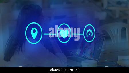 Working two colleagues typing on laptop at cafe-style communal workspace, with blue overlay icons Stock Photo