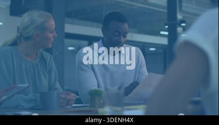 Reading mid adult man wearing sweater, holding printed papers in conference room with mug Stock Photo