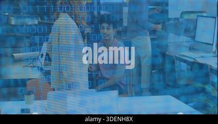 Sitting man in pink polo looking at camera, shared workspace with coffee cup and binary overlay Stock Photo
