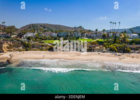 Aerial view of turquoise waters kissing the sandy shores beneath cliffside homes and lush greenery, a blend of coastal tranquility and urban life, Lag Stock Photo