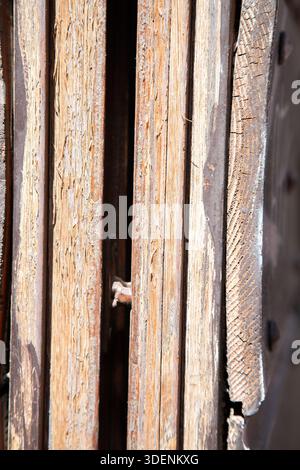 old rustic wood, sunlit aged wooden planks, weathered boards displaying peeling paint and rusted nails Stock Photo