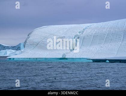 18.08.2025, Eisfjörd zwischen Ilimanaq und Ilulissat Ein großer Eisberg mit unterschiedlichen Formen, Strukturen, Löchern und Farben treibt auf dem Wasser. Je nachdem wie das Licht auf das Wasser fällt, ändert sich die Farbe des Wassers. Wie schnell der Eisberge schmelzen, konnte man hier sehr gut beobachten. *** 18 08 2025, Icefjord between Ilimanaq and Ilulissat A large iceberg with different shapes, structures, holes and colors floats on the water Depending on how the light falls on the water, the color of the water changes How fast the icebergs melt could be observed very well here Stock Photo