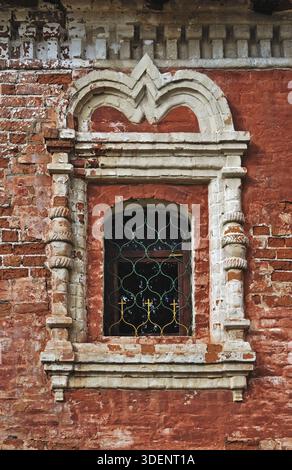 Peeling brick wall of an ancient monastery and stucco window Stock Photo