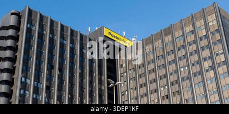 Poste Italiane - Italian Post logo sign, modern facade, headquarters building, 1970s architecture. EUR, Rome, Italy, Europe, blue sky, copy space Stock Photo