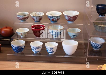 This image showcases an elegant display of teacups, emphasizing traditional craftsmanship, colors, and unique patterns that enhance tea drinking cultu Stock Photo