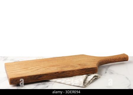 Wooden cutting board and napkin on marble table against white background Stock Photo