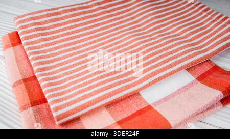 Damaged natural cotton kitchen towel with a hole in it on a wooden table. Stock Photo