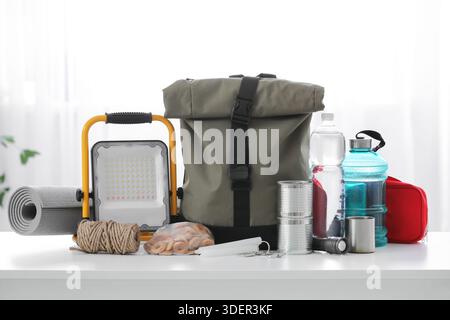Emergency backpack with necessities on table in room Stock Photo