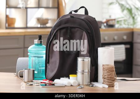 Emergency backpack with necessities on table in kitchen Stock Photo